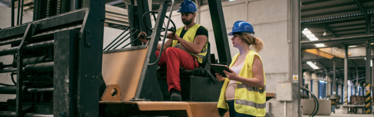 pregnant employee talking to forklift driver
